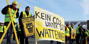 Menschen demonstrierten mit einem Kreuz und einen Plakat gegen CO2-Verpressung unter dem Wattenmeer