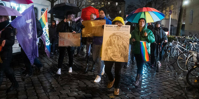 Frauen und Mäner demonstrieren auf einer Straße