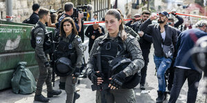 Israelische Polizei auf einer Straße, im Hintergrund Passanten