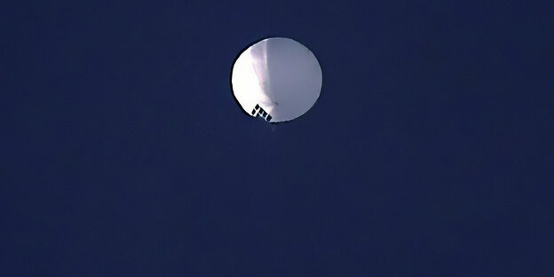Ein weißer Ballon vor dunklem Himmel