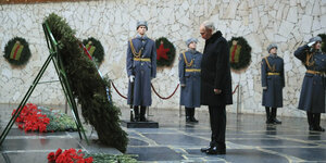 Putin vor einem Denkmal, neben ihm stehen uniformierte Soldaten