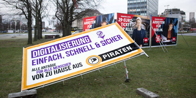 Ein Plakat der Piraten liegt vor anderen Plakaten der SPD