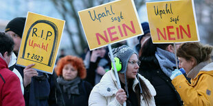 jüngere Frauen in Winterkleidung halten Schilder hoch: Upahl sagt Nein oder R.I.P Upahl