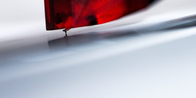 A needle on a turntable scans a record