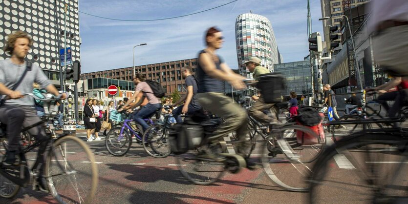 Zahlreiche Fahrräder fahren auf einer innerstädtischen Straße in beide Richtungen