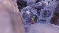 Animation eines Hasens mit Hasenluftballon, der in lilafarbenem Gestein sitzt