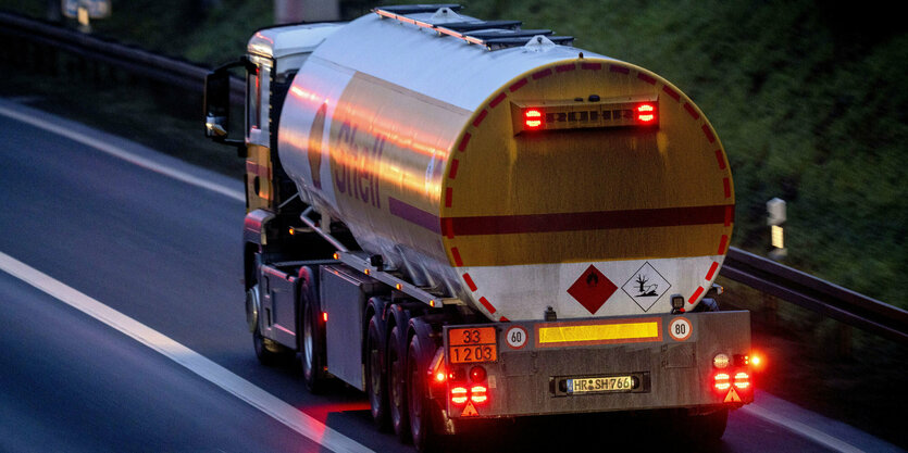 Ein Tanklaster fährt in der Abenddämmerung auf einer Straße