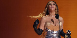 Beyonce hält einen Grammy in den Händen und schließt die Augen