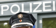 Die Mütze eines Polizisten vor dem Schriftzug "Polizei".