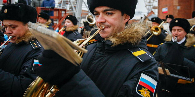 Soldat mit Pelzmütze spielt Trompete