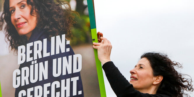 Bettina Jarasch hängt ein Wahlplakat auf