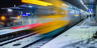 Ein fahrender Zug an einem Bahnsteig