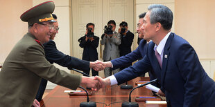 General Hwang Pyong So (links) und Südkoreas Wiedervereinigungsminister Hong Yong-pyo recihen sich die Hände.