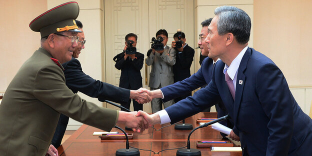 General Hwang Pyong So (links) und Südkoreas Wiedervereinigungsminister Hong Yong-pyo recihen sich die Hände.