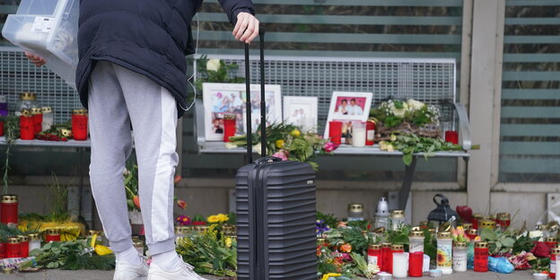 Eine Reisende schaut sich im Wartehäuschen am Bahnhof Blumen etc. an