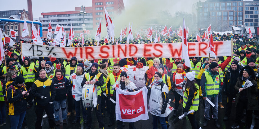 „15% Wir sind es wert“ steht auf dem Transparent, das Demonstrantinnen und Demonstranten vor der Ver.di Bundeszentrale auf der Schillingbrücke halten