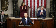 Joe Biden lächelt und gestikuliert am Rednerpult, hinter ihm applaudieren Kamala Harris und Kevin McCarthy
