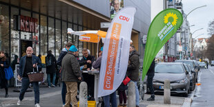 Menschen stehen um zwei Wahlkampfstände herum