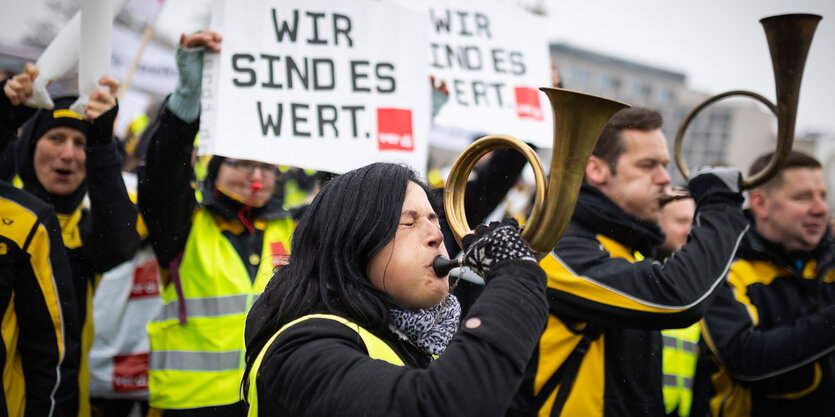 Postangestelte mit Posthörnern und Plakaten