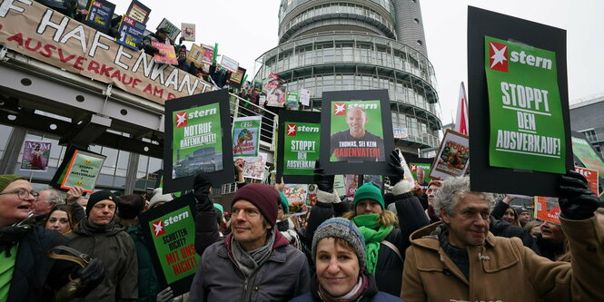 Menschen protestieren mit Schildern auf dem "Stern" steht