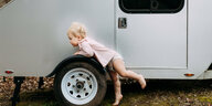 Ein Baby vor einem Wohnwagen