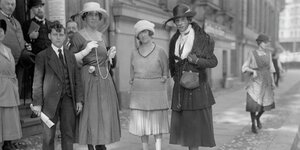 Historisches Schwarzweiß-Foto von Menschen in Kleid und Anzug