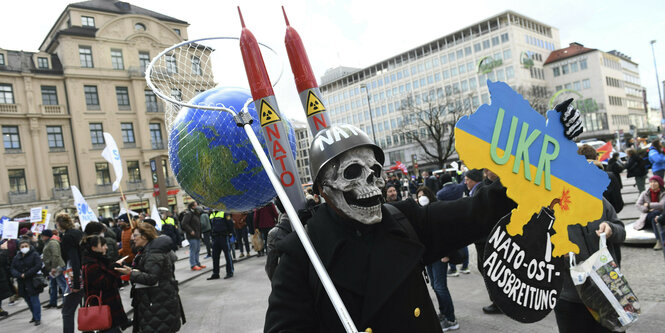 Ein Demonstrant mit Stahlhelm und Totenkopfmaske