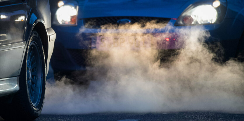 Aus einem Auto-Auspuff kommt eine große Abgas-Wolke.