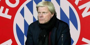 Ex-Fußballer Oliver Kahn vor einem FC Bayern München Logo