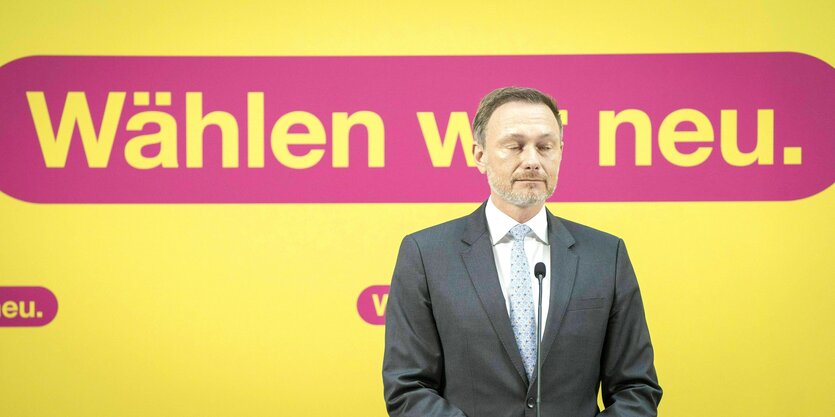 Christian Lindner steht mit geschlossenen Augen vor einem Plakat: Wählen wir neu.