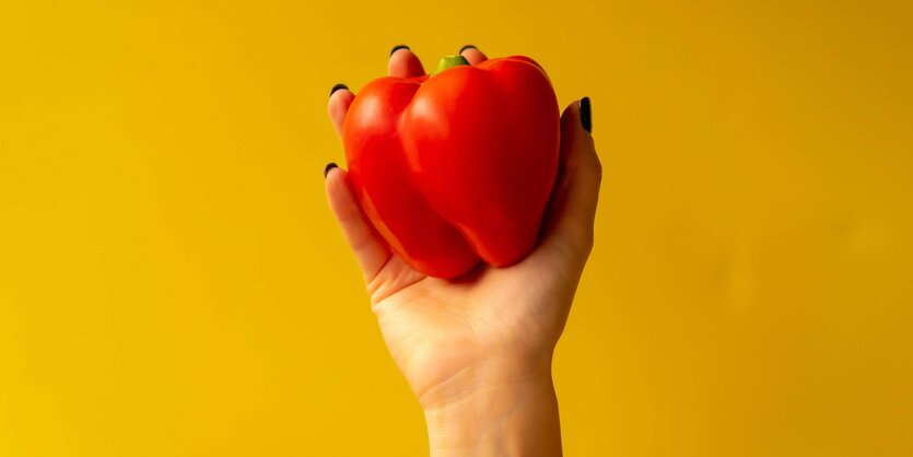 Eine Hand mit einer Paprika