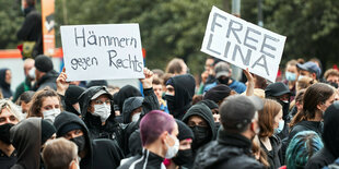 Demonstraten protestieren aus Solidarität mit Lina E. und halten Transparente hoch, die u.a. sagen: "Hämmern gegen rechts"