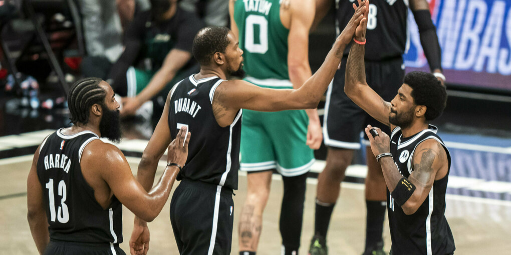 James Harden, Kevin Durant und Kyrie Irving klatschen sich auf dem Spielfeld ab