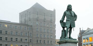 Eine Statue von Händel, dahinter ist ein Rathaus zu sehen
