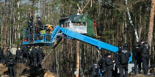 Eine blaue Hebehübhne, drum herum sind Menschen versammelt