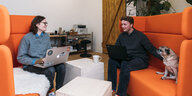 Julia und Henning auf orangefarbenen Sitzmöbeln im Torfhub, einem Coworkingspace in Kastorf