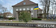 Vor dem Museum Karlshorst weht die Ukraineflagge, der Schriftzug Deutsch-Russisches Museum ist so durchgestrichen, dass da nur noch Museum steht