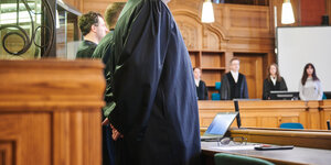 AnwältInnen in schwarzen Roben in Gerichtssaal