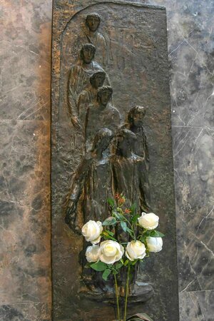 Relief aus Bronze mit dem Bild der hingerichteten Mitglieder der Weissen Rose, an denen ein Strauß weisser Rosen lehnt Relief aus Bronze mit dem Bild der hingerichteten Mitglieder der Weissen Rose, an denen ein Strauß weisser Rosen lehnt