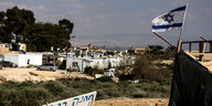 eine israelische Flagge weht über der Siedlung, die aus Wohncontainern besteht