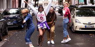 Vier Freundinnen, freudige Pose auf der Straße