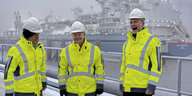 Habeck, Scholz und Lindner mit Helmen vor einem LNG-Terminal
