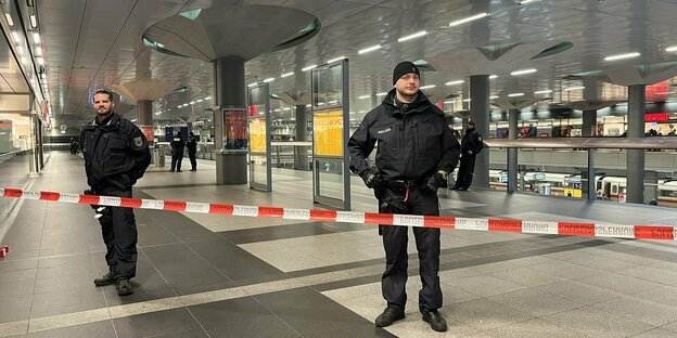 Mit Flatterband abgesperrter Bereich am Berliner Hauptbahnhof, von 2 Polizisten bewacht