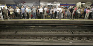 Viele Menschen stehen auf einem U-Bahnsteig und warten auf den Zug