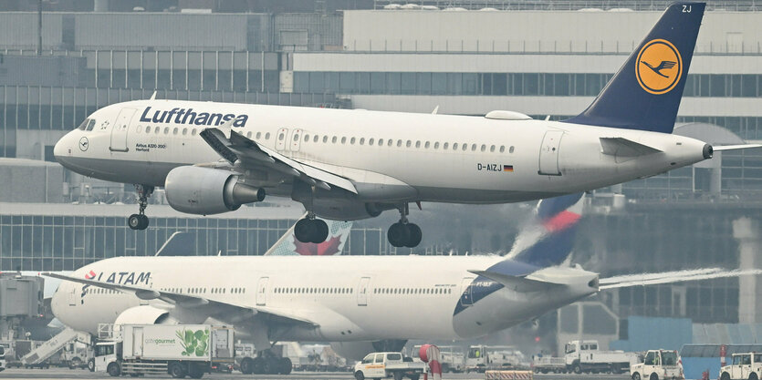 Zwei Flugzeuge auf dem Flughafen, eines landet