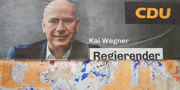 Ein abgerissenes Wahlplakat der CDU mit dem Portrait von Kai Wegner