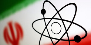 Ein Atomsymbol vor der iranischen Flagge