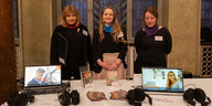 3 Frauen stehen hinter einem Infotisch mit Flyern von multicult.fm und Laptops, wo man mit Kopfhörern den Livestream hören kann