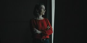 Die Verteidigungsexpertin Claudia Major steht in einem dunklen Raum, ein Lichtstrahl aus einem ansonsten verdunkelten Fenster fällt auf sie