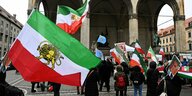 Am Münchner Odeonsplatz demonstrieren Menschen mit der Fahne der iranischen Opposition